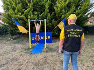 Семирічний Філіп Нагорний виконує підйоми на перекладині під наглядом представника реєстру рекордів
