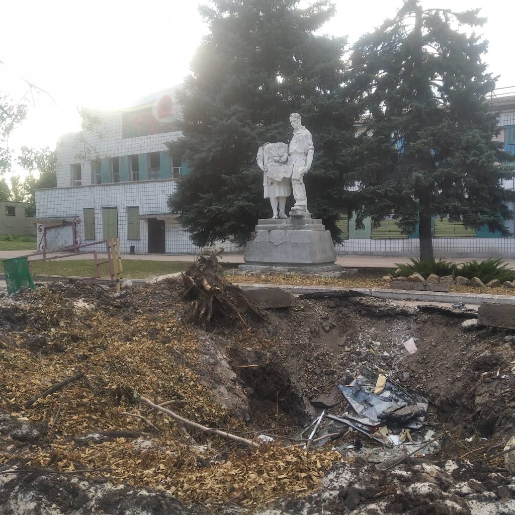 Статуя чоловіка з дитиною на тлі розритої ями та сміття в окупованому Криму