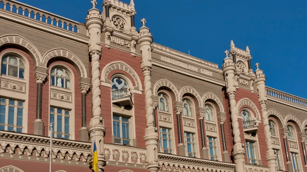 Будівля Національного банку України з прапором на тлі неба