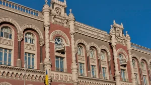 Будівля Національного банку України з прапором на тлі неба