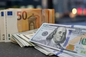 Банкноти по 100 доларів США та 50 євро на столі