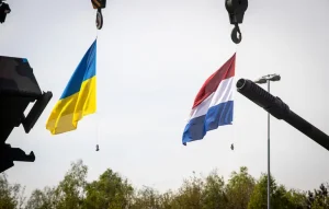Прапори України та Нідерландів на тлі стволів військової техніки