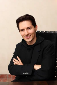 Павло Дуров усміхається зі схрещеними руками в чорному одязі