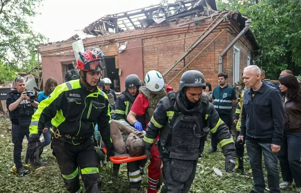 Рятувальники евакуюють пораненого після атаки дрона на підприємство в Харкові