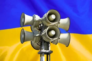 Сирени повітряної тривоги на тлі прапора України