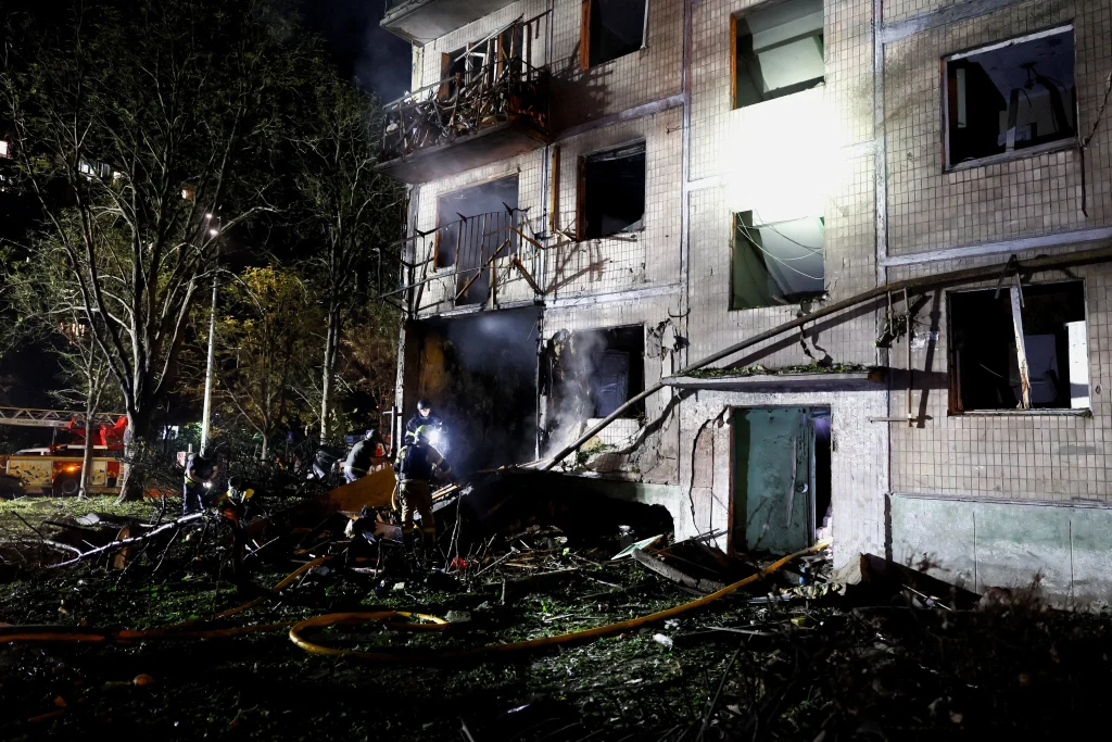 Пошкоджений житловий будинок у Києві після нічної балістичної атаки, рятувальники серед уламків