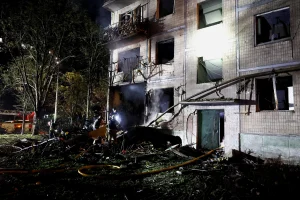 Пошкоджений житловий будинок у Києві після нічної балістичної атаки, рятувальники серед уламків