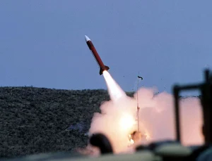 Червона ракета з білим наконечником стартує з яскравим полумям і димом