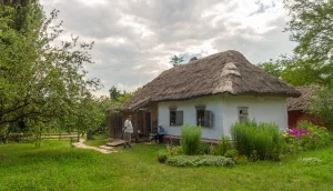 Подружье у белой хаты с камышовой крышей в зелёном саду